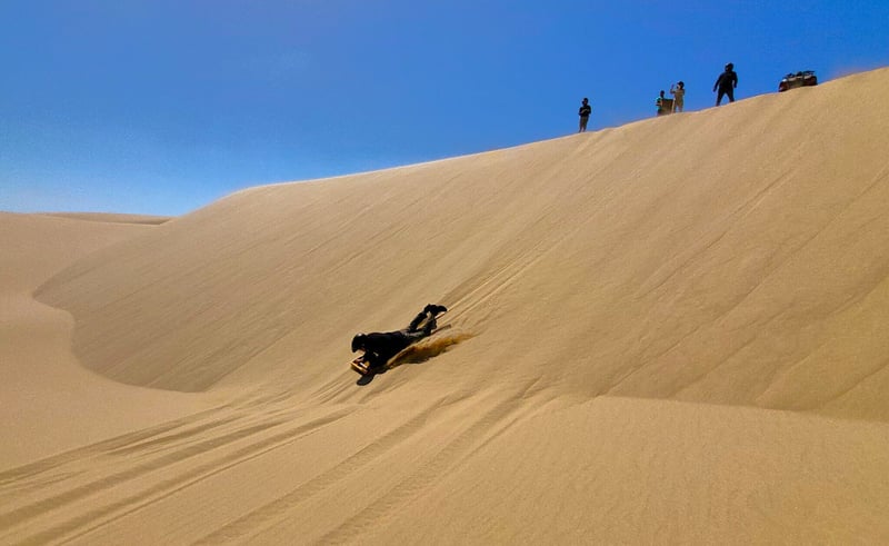 Micato-Safaris-Hot-List-2023_Sandboarding-Skeleton-Coast-Namibia_Brian-Nel-2048x1257